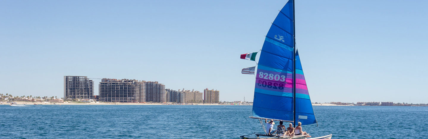 Regatta sailboat on the water with the three Las Palomas properties in the background