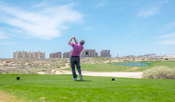 Golfer taking a swing on the Las Palomas course