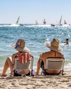 Two people sitting on beach chairs on the beach