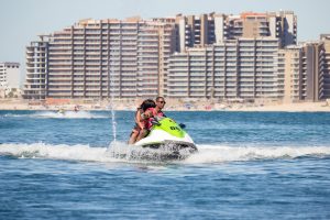 Person on a waterbike with buildings in the background